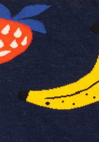 Niebieska tkanina z zabawnym wzorem przedstawiającym czerwoną truskawkę z białymi nasionkami oraz żółtego banana z czarnymi akcentami.