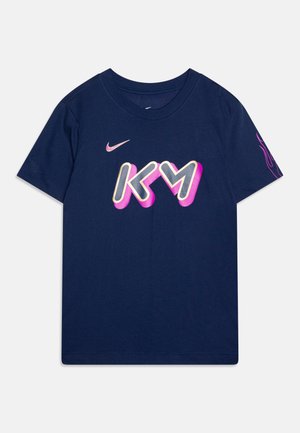 Tamno plava pamučna majica s izrazitom bijelom i ružičastom grafikom "KM" te malim Nike logotipom na gornjoj lijevoj strani, kratki rukavi.