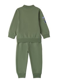 Chándal verde oliva hecho de una tela suave, que incluye una chaqueta con cremallera y puños acanalados, y pantalones a juego con cintura elástica.
