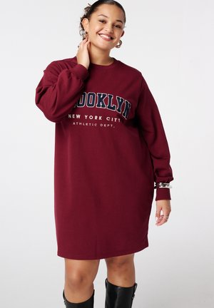 Bordeaux sweatshirtjurk met lange mouwen, voorzien van de tekst "BROOKLYN", witte accenten en een losse pasvorm. Glad, zacht stoftextuur.