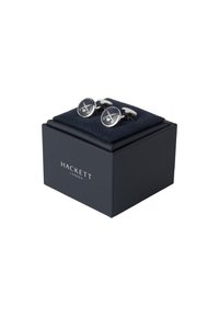 Stříbrné manžetové knoflíčky s kruhovým designem, které mají střed z tmavě modrého smaltu, prezentované v elegantní tmavě modré krabičce s měkkým vnitřkem.