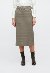 Καρό μίντι φούστα σε καφέ και μπεζ με ζώνη που διαθέτει κυκλικό αγκράφα. Το υλικό έχει απαλή υφή· ίσια γραμμή.