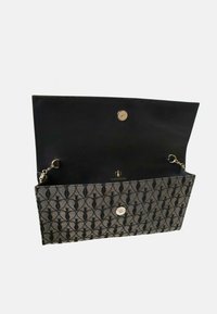 Bolso de mano negro con patrón, cierre magnético, detalle de cadena en el interior y un interior liso negro. Presenta un logo sutil en la parte posterior.