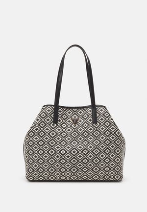 Torba typu tote w czarno-białe wzory z dwoma czarnymi uchwytami i małym trójkątnym logo Guess na środku z przodu.