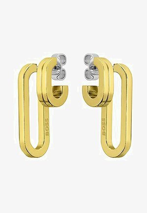 Orecchini in metallo dorato con un design geometrico moderno, caratterizzati da una forma ad anello e accenti argento nella parte superiore. Logo del brand visibile.