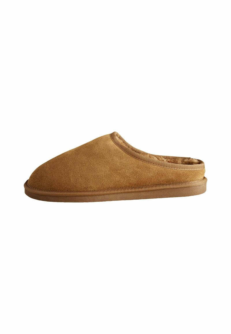 Tan suede slipper with a rounded toe, soft interior lining, and subtle stitching along the collar and sole, featuring a low-profile design.