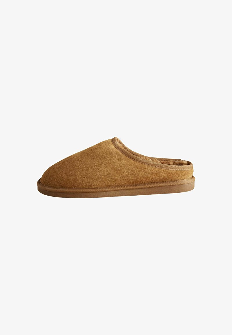 Tan suede slipper with a rounded toe, soft interior lining, and subtle stitching along the collar and sole, featuring a low-profile design.