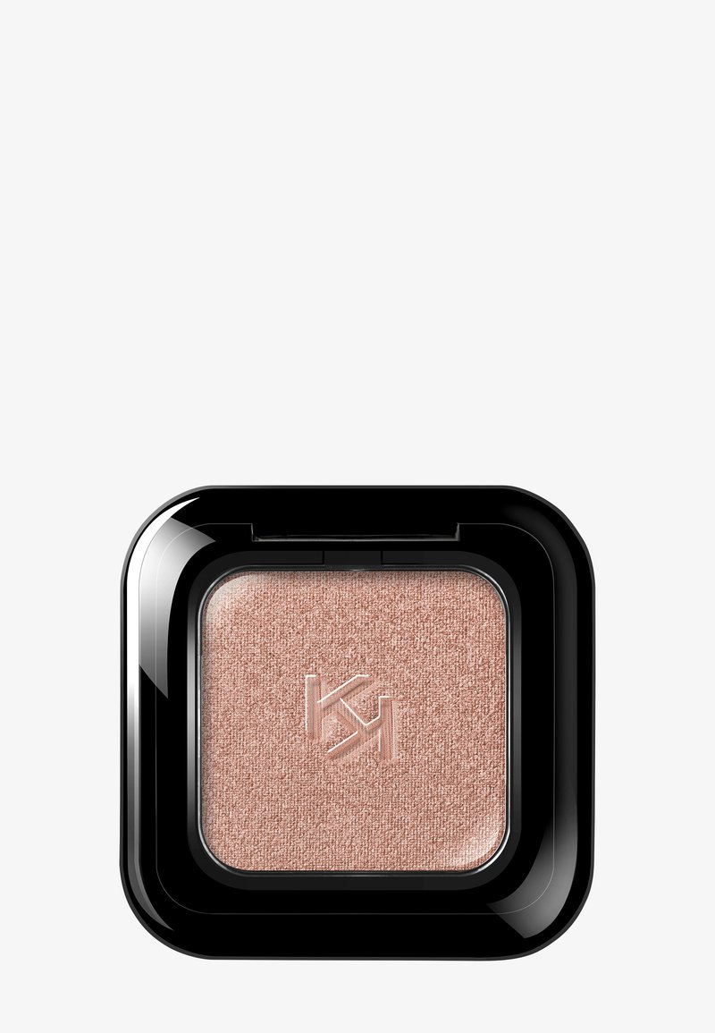 Ombre à paupières pressée couleur or rose avec surface texturée et logo embossé à l'intérieur d'un étui carré noir brillant.