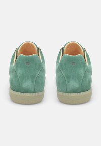 Sneakers in suede verde con una finitura testurizzata, interno beige e suola in gomma caratterizzata da un motivo a diamante sul bordo.