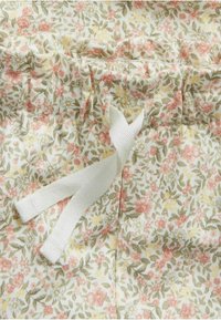 Bloemendessinfabric met kleine roze, gele en groene bloemen op een witte achtergrond; inclusief een witte trekkoord.