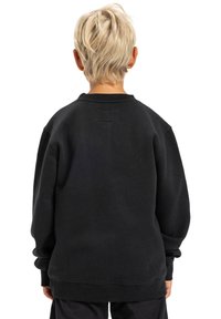 Sudadera negra con un corte relajado, cuello redondo y puños de canalé. Material de algodón suave, con un detalle de costura mínima en la espalda.