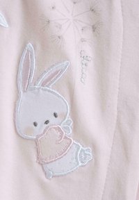Indumento ricamato rosa con un coniglietto che tiene una coperta, con cuciture bianche e rosa chiaro. Tessuto morbido con leggere scintillii.