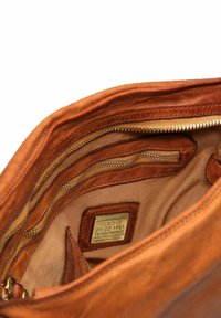 Interno di una borsa in pelle marrone con vari taschini con zip e un'etichetta che indica "CAMPOMAGGI," "TEODORANO," e "MADE IN ITALY."