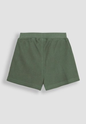 Zöld rövidnadrág, textura waffle kötésű dizájnnal és rugalmas derékkal. A hátsó nézet sima, egyszerű stílust és tiszta éleket mutat.