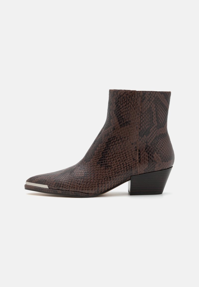 Stivaletto con stampa serpente marrone, punta affusolata e tacco basso a cubetto. Caratterizzato da una texture liscia e un accent metallico nella parte anteriore.