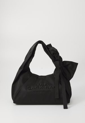 Bolso de tote negro de nylon con un suave asa anudada, que presenta un texto embosado que dice "THE SACK BAG" y una textura mate lisa.