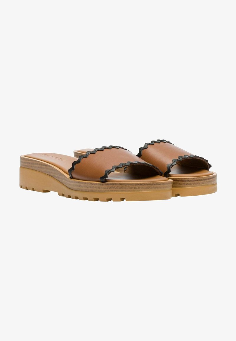 Sandales slides en cuir marron avec bordure noire festonnée sur semelles compensées épaisses couleur fauve, vues de profil sur fond blanc.