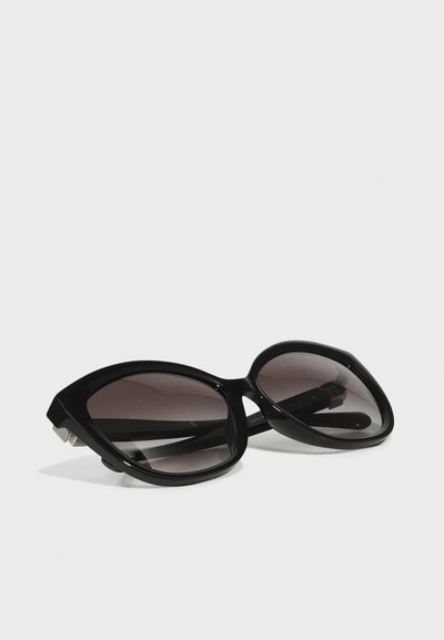 Black cat-eye sunglasses with gradient dark gray lenses. Thick plastic frame with smooth texture and silver accents on the temples.