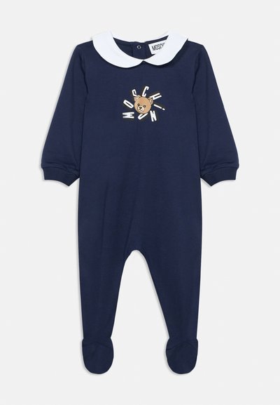 Temno modri otroški bodi z belim ovratnikom Petrovček, dolgimi rokavi, nogavicami in motivom medvedka z napisom "Moschino" na prsih.