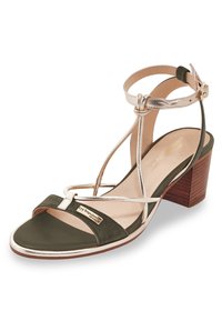 Sandal in suede verde con dettagli metallici dorati, design open toe, con cinturino alla caviglia e tacco a blocco in legno marrone. Presenta un logo sul lato.