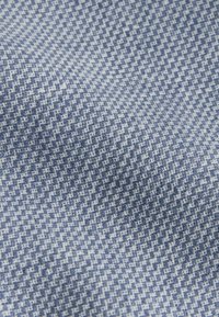 Textilná tkanina s geometrickým vzorom v modrej a bielej farbe, mäkká na dotyk, s jemne splývavým vzhľadom.