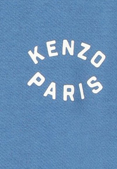 T-shirt en coton bleu avec un texte blanc disposé en courbe qui indique "KENZO PARIS" centré sur le devant. Texture lisse.