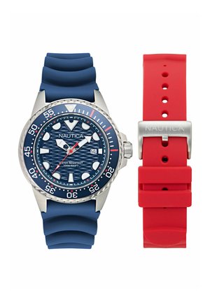 Montre Nautica pour homme avec un bracelet en silicone bleu, boîtier en acier inoxydable, cadran bleu texturé, accents rouges et un bracelet supplémentaire en silicone rouge.