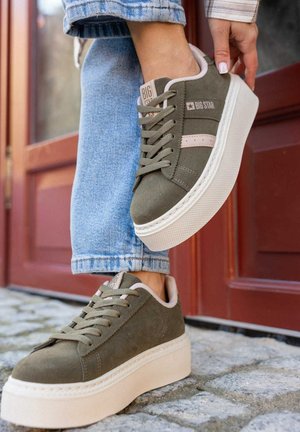 Zielone zamszowe trampki na platformie z beżowymi akcentami i sznurówkami. Posiadają teksturowaną białą gumową podeszwę, logo z boku oraz przeszycia.