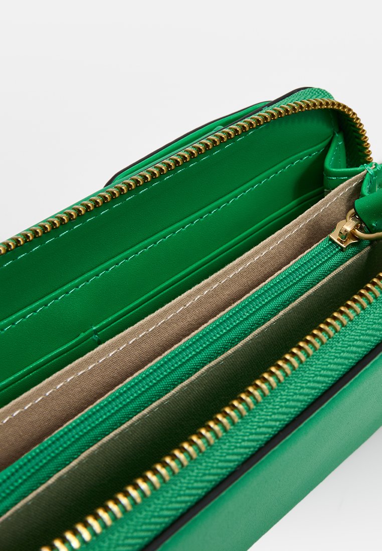 Cartera verde con un exterior texturizado, detalle de cremallera dorada y múltiples compartimentos interiores en telas y acabados de cuero contrastantes.