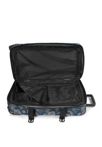 Pehmeäkantinen käsimatkatavarakassi sinisellä trooppisella kuviolla, mustalla vuorauksella, useilla osastoilla ja kaksoisvetoketjulla.