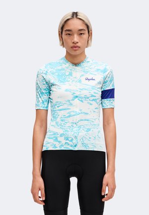 Personne portant un maillot de cyclisme à motifs bleu clair et blanc avec le logo "Rapha" et un cuissard cycliste noir uni, face à l'avant.