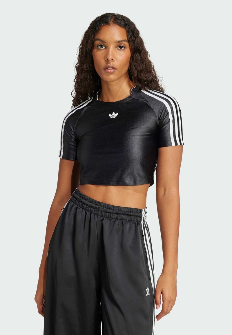 Svart kortärmad sporttopp med glänsande yta, försedd med vita Adidas-ränder längs axlarna och en liten logotyp i mitten.