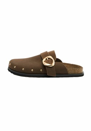 Brown slip-on clog with gold buckle strap, gold studs on upper, cork footbed, and black sole.