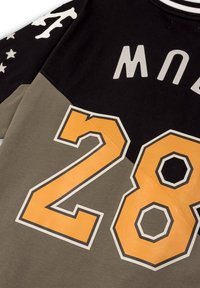 Sudadera negra y verde oliva con gráfico naranja '28', estrellas blancas y patrones de huesos en las mangas, y letras grises.