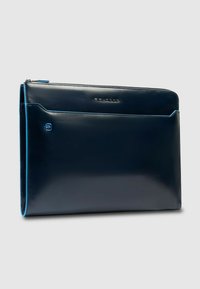 Funda para portátil de cuero azul marino con textura suave, cierre de cremallera, bolsillo frontal y detalles contrastantes en azul claro. Incluye detalle del logo.