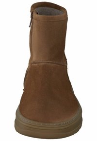 Brun ruskind ankelstøvle med en glat tekstur, sidelukning med lynlås og rund tå. Sålen er lysebrun gummi med et struktureret mønster.