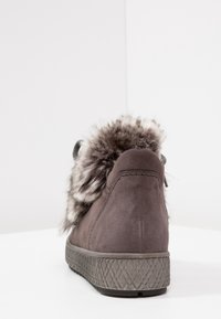 Stivaletto alla caviglia in suede grigio scuro con colletto in pelliccia sintetica e suola in gomma stampata. Presenta una punta arrotondata e una suola testurizzata.