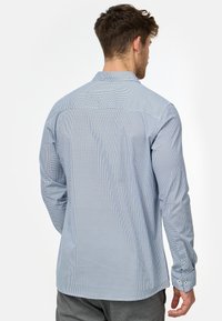 Blåternet langærmet skjorte lavet af bomuld, med en button-down krave, manchetter med en enkelt knap og en afslappet pasform.