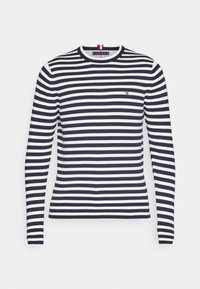 Marinblå och vit randig långärmad t-shirt med rund halsringning och liten logodetalj på bröstet, tillverkad av ett lättviktigt material.