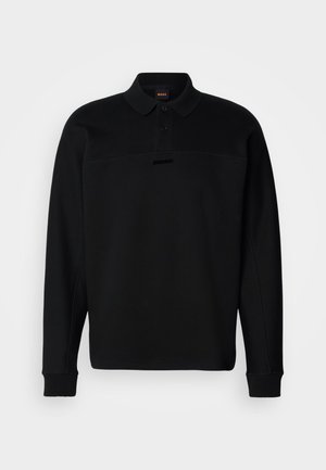 Črna polo majica dolgimi rokavi, narejena iz mehke tkanine, z ovratnikom na gumb in subtilnim logotipom na prsih. Prisotni so rebrasti manšeti.