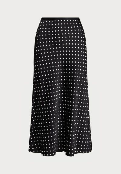 Black polka dot skirt made of smooth fabric, featuring a high waist and A-line silhouette, adorned with evenly spaced white dots.