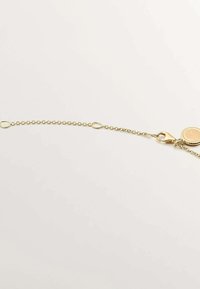 Cadena de oro con eslabones ovalados, un cierre tipo langosta y un charm redondo con borde texturizado. Acabado suave, diseño ligero.