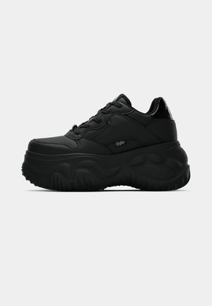 Sneakers platform nere realizzati in materiale sintetico liscio, caratterizzati da una suola spessa, forma arrotondata e design con lacci. Dettaglio del logo discreto presente.