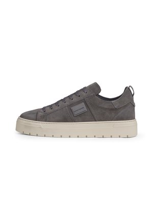 Sneaker scamosciata grigia a taglio basso con suola spessa bianca sporca, chiusura frontale con lacci e linguetta sul tallone.