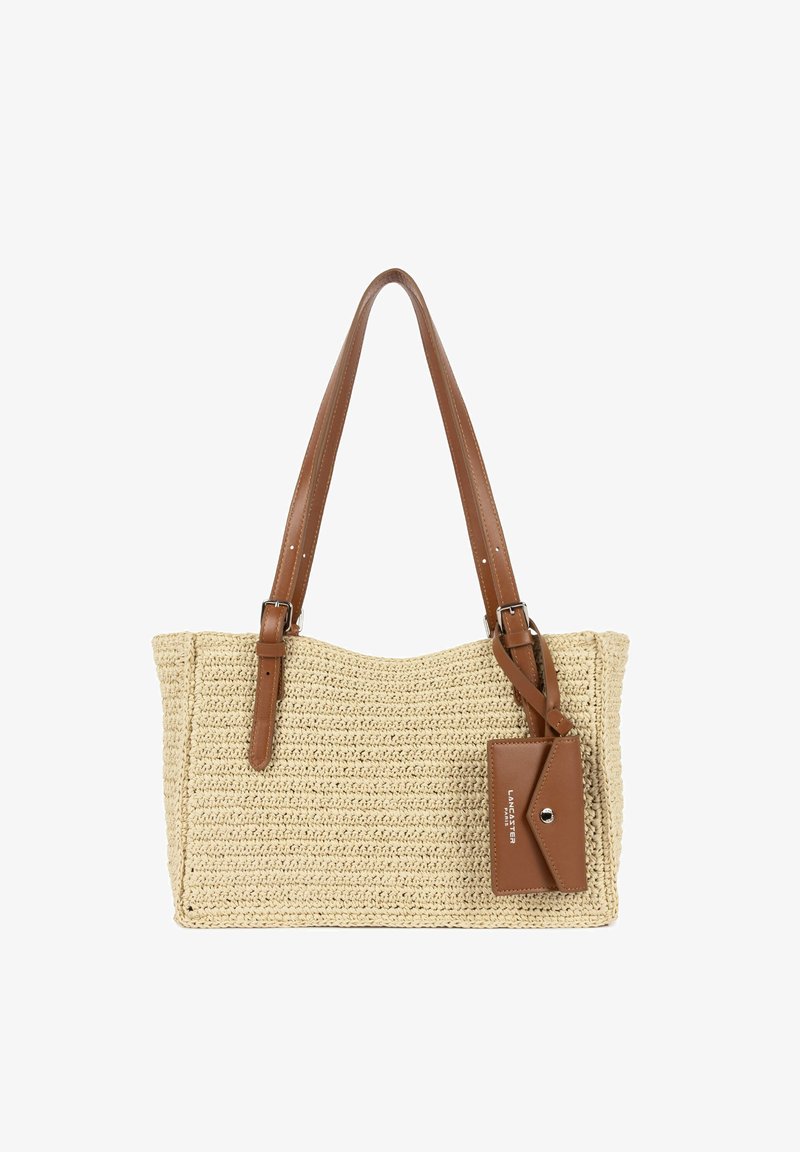 Sac tote tissé beige avec poignées en cuir marron et pochette en cuir marron attachée avec une fermeture argentée et texte blanc en relief.