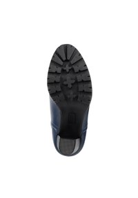 Zapato de cuero azul con una suela de goma negra texturizada que presenta un patrón de formas cruzadas y un acento de tacón liso.