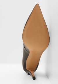 Černá kožená vysoká podpatková bota s špičatou špičkou a štíhlým podpatkem, která má hladký svršek a béžovou stélku.