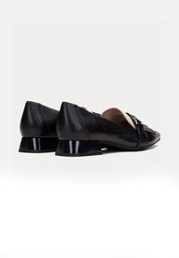 Schwarze Lederballerinas mit einem kleinen, eckigen Absatz. Zu den Merkmalen gehören ein geflochtenes Design an der Vorderseite und ein glattes Innenfutter.