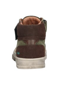 Bruine en olijfgroene hoge schoen met een suedetextuur, klittenbandsluiting en lichte rubberen zool. Beschikt over een gevoerde schacht en accenten.