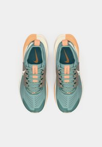 Teal sportieve schoenen met grijze en oranje accenten. Voorzien van gaas- en geperforeerde materialen, ronde neus en platte vetersluiting.
